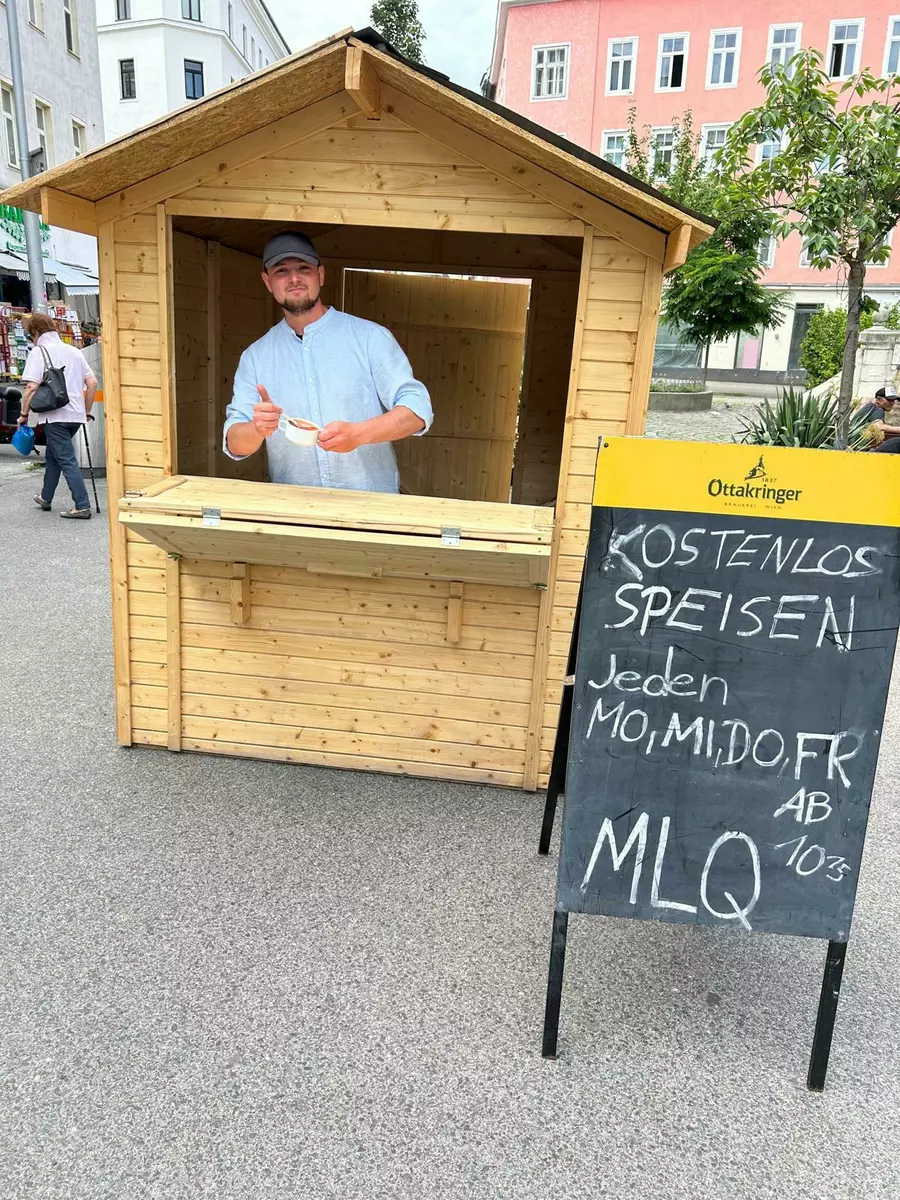 Mario Orth im Holzcontainer am Siebenbrunnenplatz, aus dem kostenlose Speisen verteilt werden